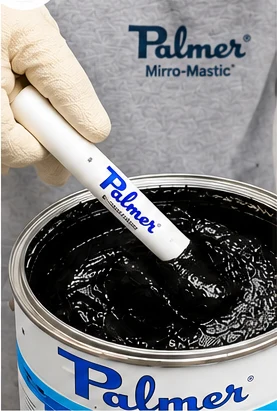 Installer scooping black mirror mastic from the pail using the Mastic Stik